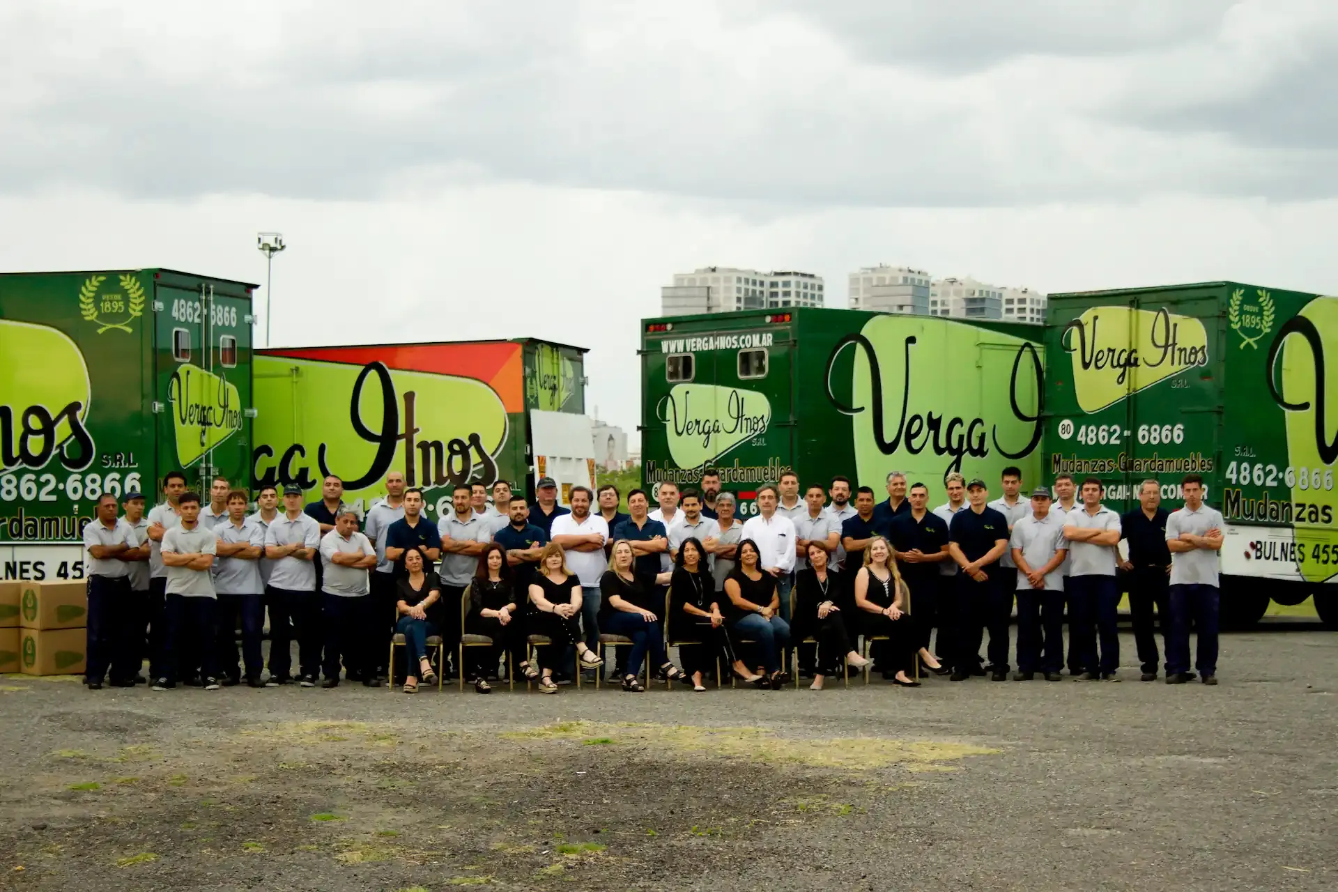 El equipo de Verga Hnos frente a su flota de camiones verdes en Buenos Aires